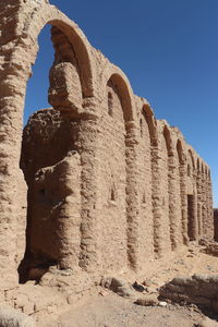 Low angle view of old building against clear blue sky
