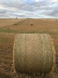 Hay bales on field against sky