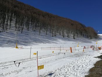 Scenic view of snow covered field against sky