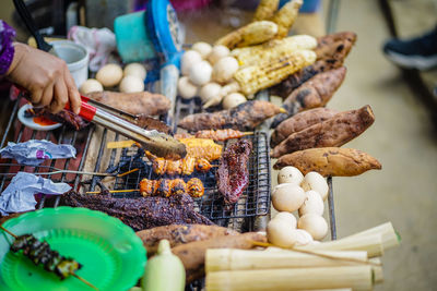 Midsection of person preparing food for sale at market stall