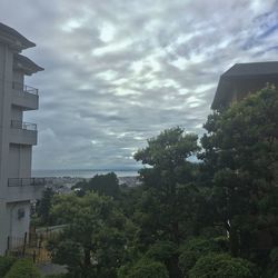 Building by sea against cloudy sky