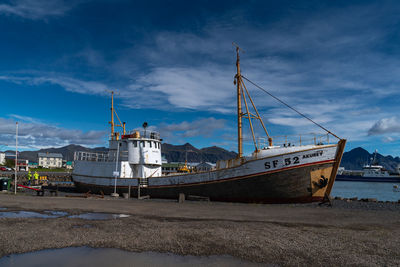 Ship moored at harbor against sky