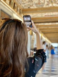 Rear view of woman photographing