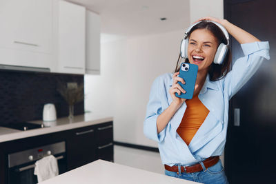 Portrait of young woman using mobile phone in office