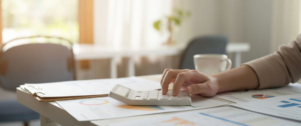 Midsection of businesswoman using laptop at office