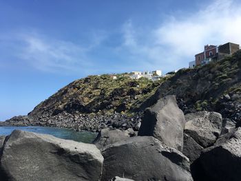 Rocks by sea against sky