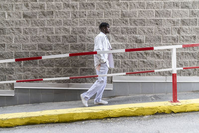 Young man walking by wall