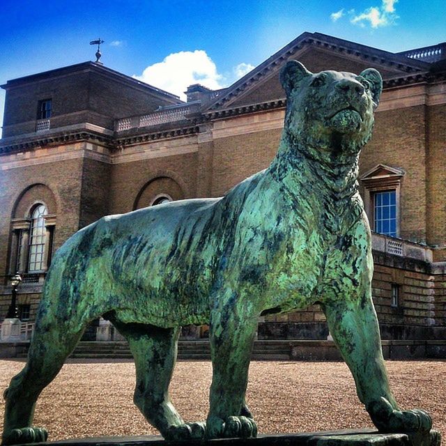 architecture, built structure, building exterior, statue, art and craft, sculpture, art, animal representation, creativity, sky, low angle view, human representation, horse, blue, sunlight, day, no people, outdoors, carving - craft product