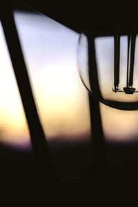 Close-up of glass window against sky during sunset