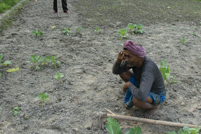 Rear view of woman working on field