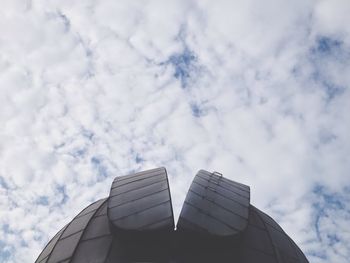 Low angle view of modern building against cloudy sky