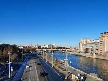 High angle view of river by city against blue sky