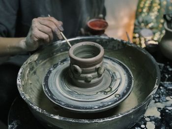 Midsection of man making pot