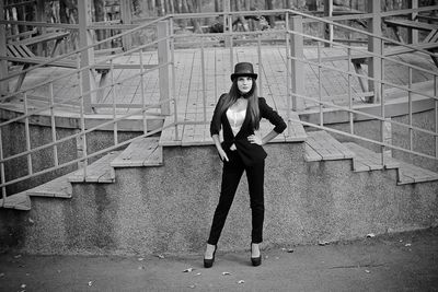 Portrait of young woman standing against built structure