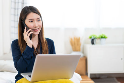 Portrait of young businesswoman using laptop at home