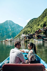 Woman sitting on boat in lake against sky