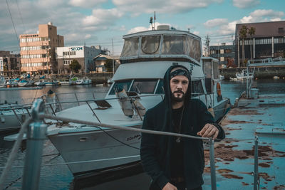 Portrait of man standing in boat against buildings