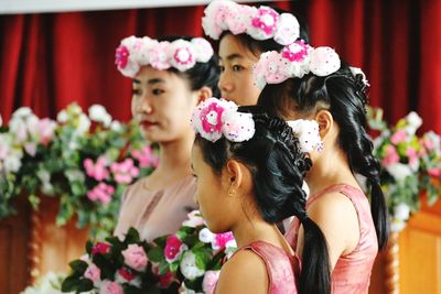 Close-up of bridesmaid wearing flowers standing in ceremony