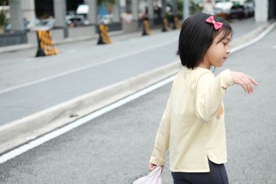 Side view of girl walking on road