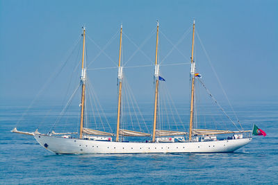 Tall ship sailing in sea against clear blue sky