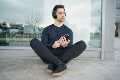 Young man with headphones on city street