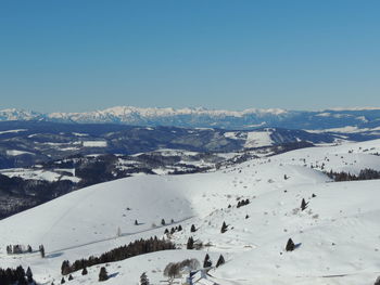 Aerial view of snow covered landscape against clear sky