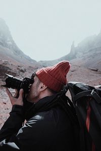 Side view of man photographing through camera