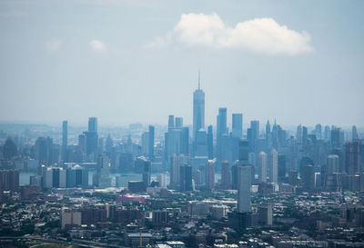 Aerial view of buildings in city against sky