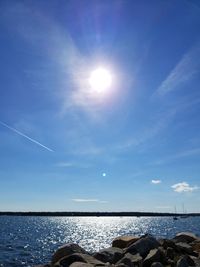 Scenic view of sea against blue sky on sunny day