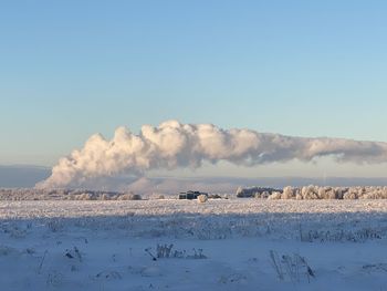 Scenic view of snowcapped field against sky