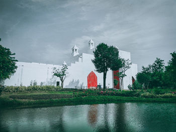 Scenic view of lake by building against sky