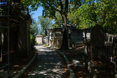 Empty road amidst buildings in cemetery