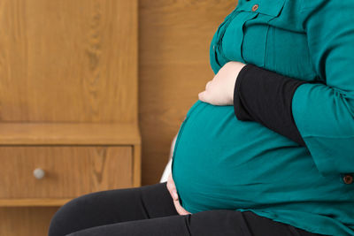 Midsection of woman with arms raised