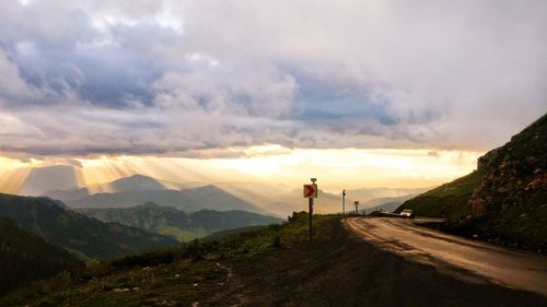 Man standing on road against sky during sunset