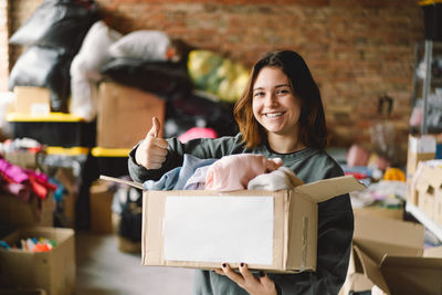 Volunteer teengirl preparing donation boxes for people.