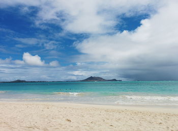 Scenic view of hawaiian beach and turquoise sea against cloudy sky