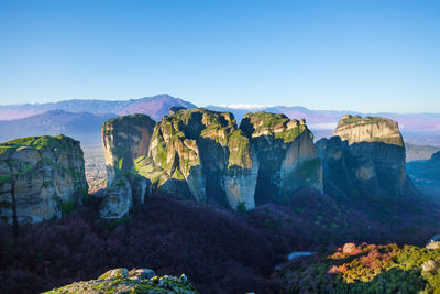 Panoramic view of rock formations against blue sky