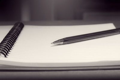 Close-up of pen with diary on table