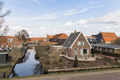 Houses and buildings in city against sky