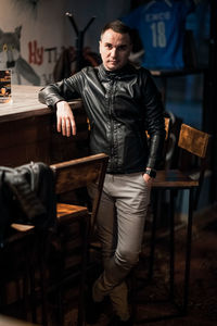 Young man looking away while sitting on table