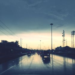 Traffic on road against cloudy sky