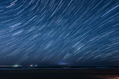 Firework display over sea against sky at night