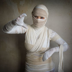 Portrait woman in mummy costume against wall during halloween