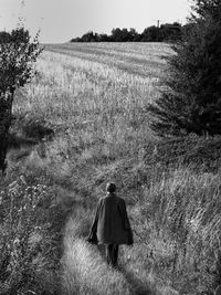 Rear view of man walking on field