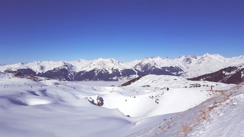 Scenic view of snowcapped mountains against clear blue sky