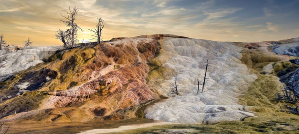 Rock formations on landscape against sky during sunset