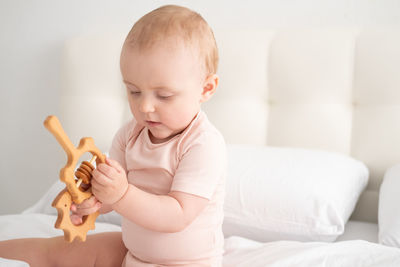 Close-up of cute baby boy sitting on bed at home