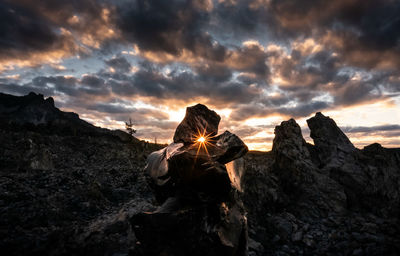 View of son seen through rock formation during sunset