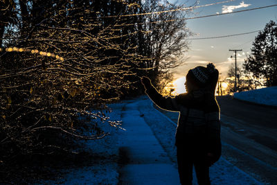 Rear view of woman standing in forest