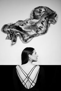 Portrait of young woman looking away against white background